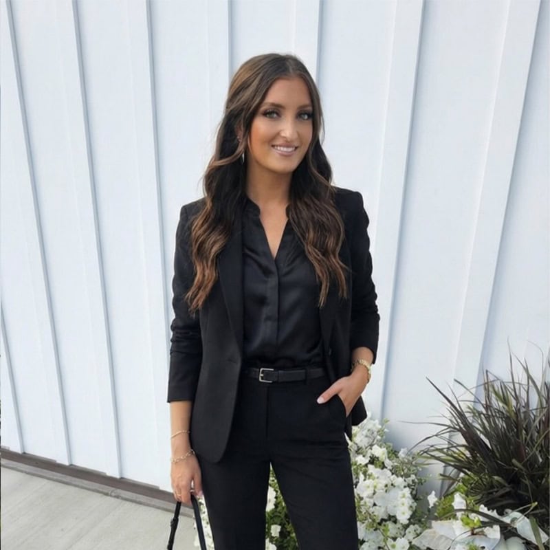 Elegant woman in black suit at luxury event, celebrating once-in-a-lifetime moments.