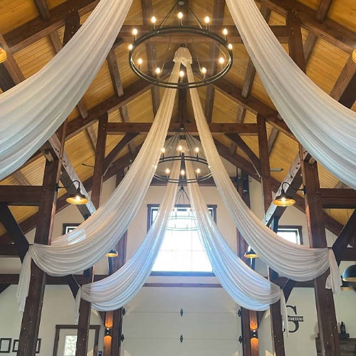 Elegant wedding or event venue with stunning draped fabric and chandelier decor.